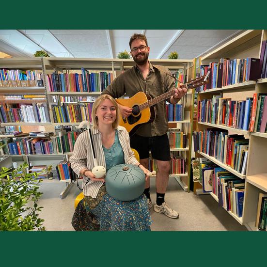 Portræt af AC og Linus i biblioteksrum