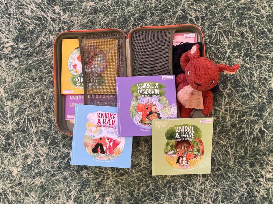 Åben Knirkekuffert med bøger og bamse