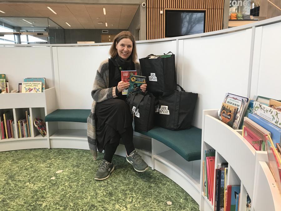 Børnebibliotekar Mette Lindstrøm Nielsen fremviser læsefamilieposerne